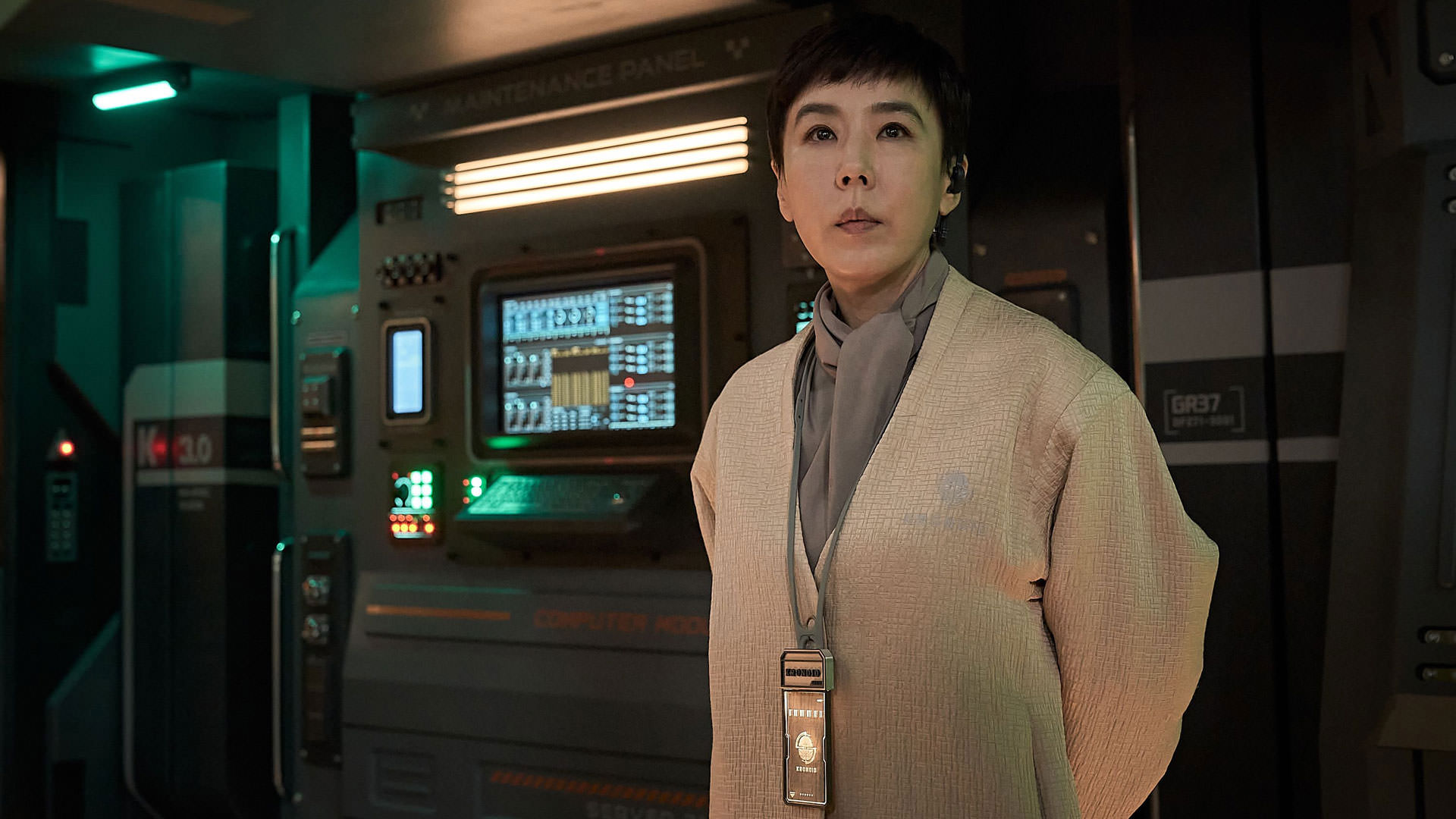 کنگ سو-یون با لباسی کرم‌رنگ ایستاده داخل یک آزمایشگاه پیشرفته در نمایی از فیلم جونگ ای به کارگردانی یون سانگ-هو