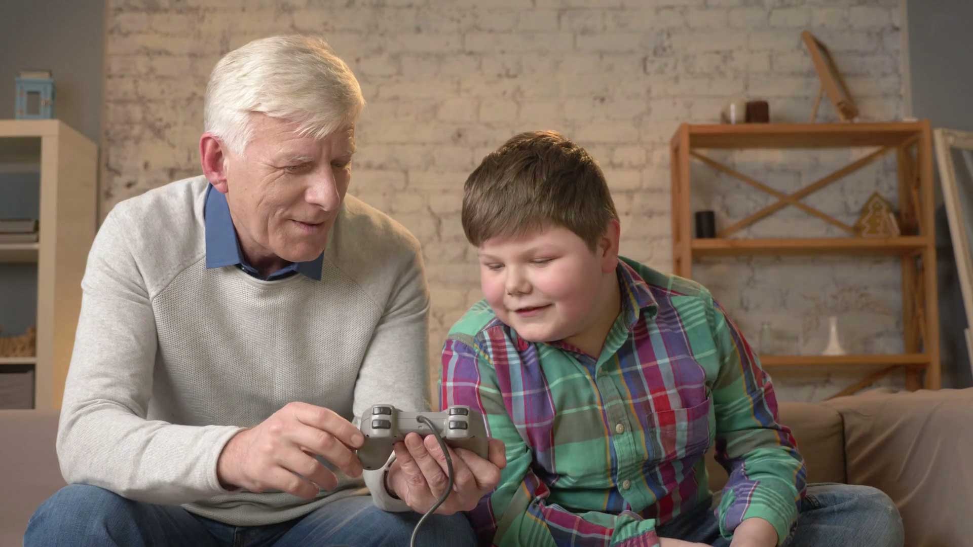 پدربزرگ و نوه در حال صحبت با یکدیگر راجع به تجربه بازی های ویدیویی