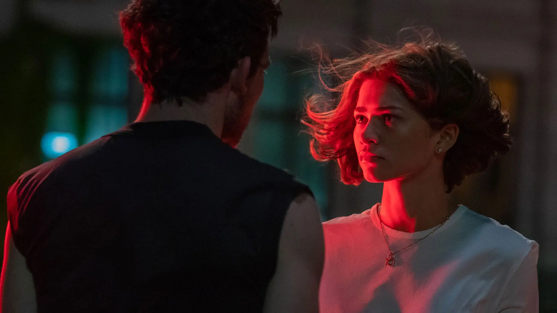 زندیا ایستاده مقابل جاش اوکانر در حالی که نوری قرمز بر چهره‌اش تابیده است در نمایی از فیلم چلنجرز به کارگردانی لوکا گوادانینو